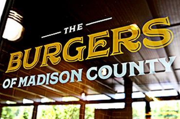 Photo shows the 'Burgers of Madison County' logo painted on glass