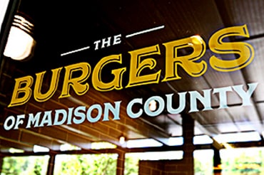 Photo shows the 'Burgers of Madison County' logo painted on glass