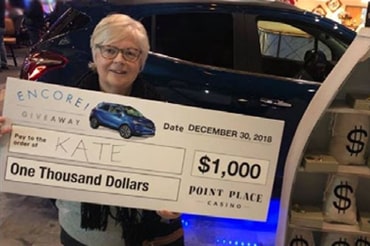 Encore $1,000 giveaway winner posing with prize check