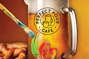 Perfect Pour Cafe pint glass full of beer with foamy head and soft twisted pretzel on the side